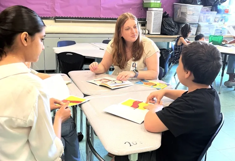 Two women at a table talking with a young boy