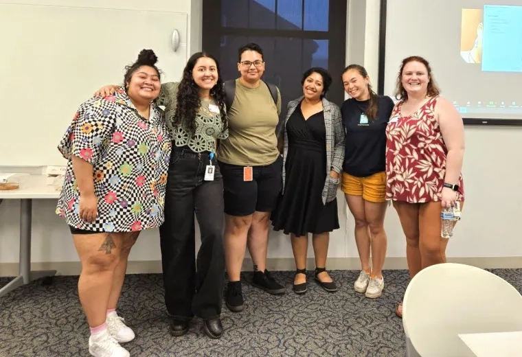 Six people in a row and smiling