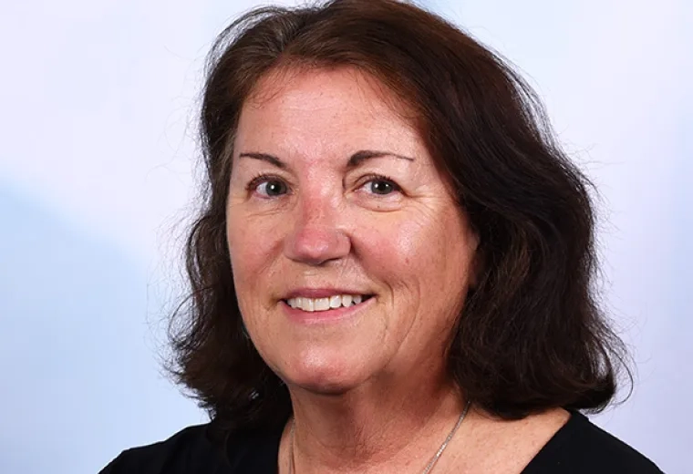 jean smiles and has shoulder length hair with a wave in it