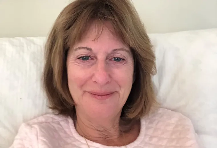 Woman sitting on couch with light pink top
