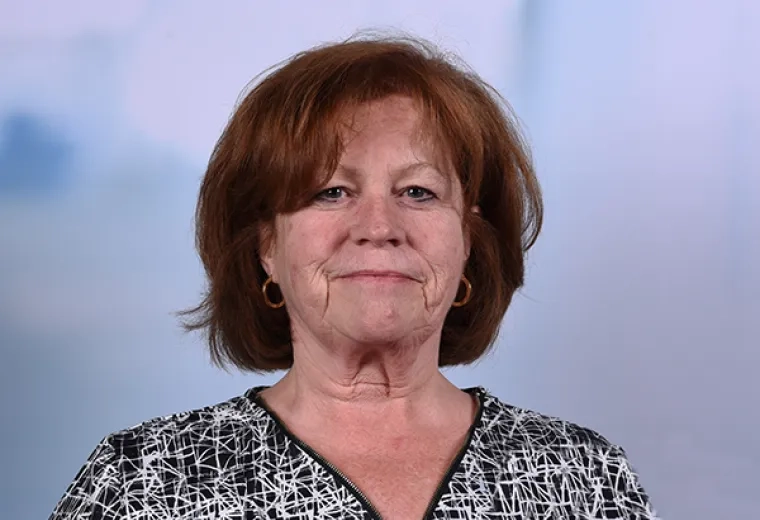 mary has red short hair and gold hoop earrings