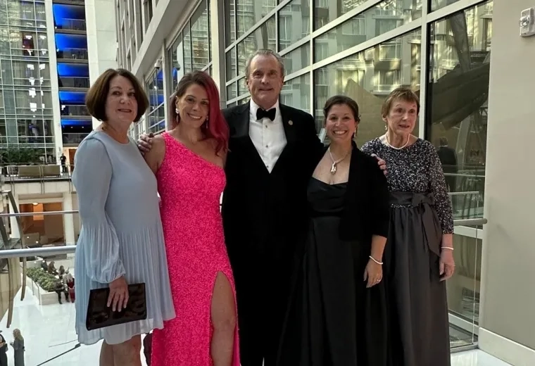 Dean Ken White stands with four women dressed up