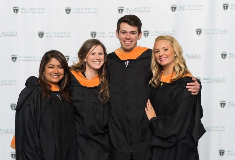 four young-looking people in black graduation gowns with golden collars