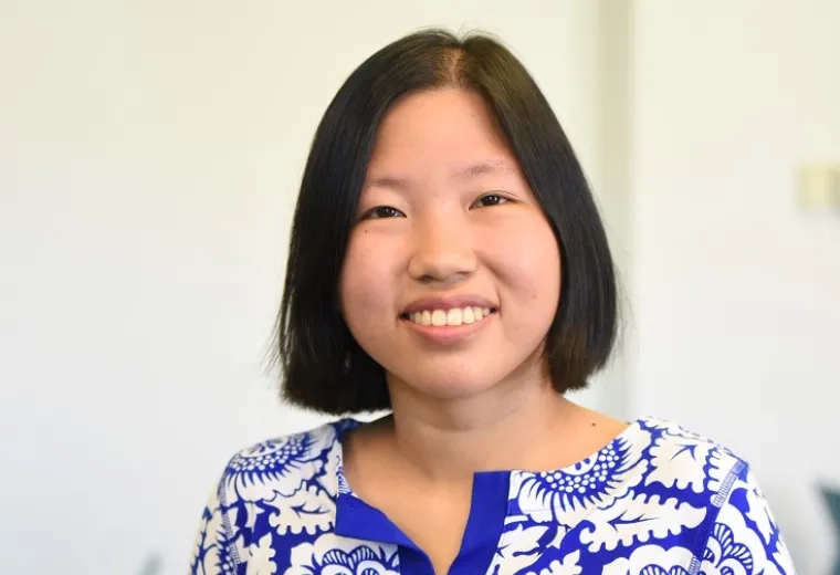 tabitha has short straight black hair and wears a cream and blue flowered top