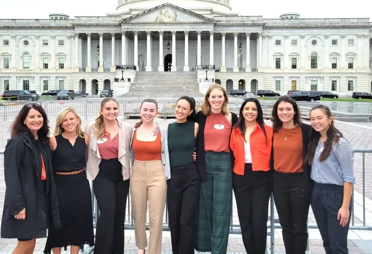 9 people standing in front of the US Capitol