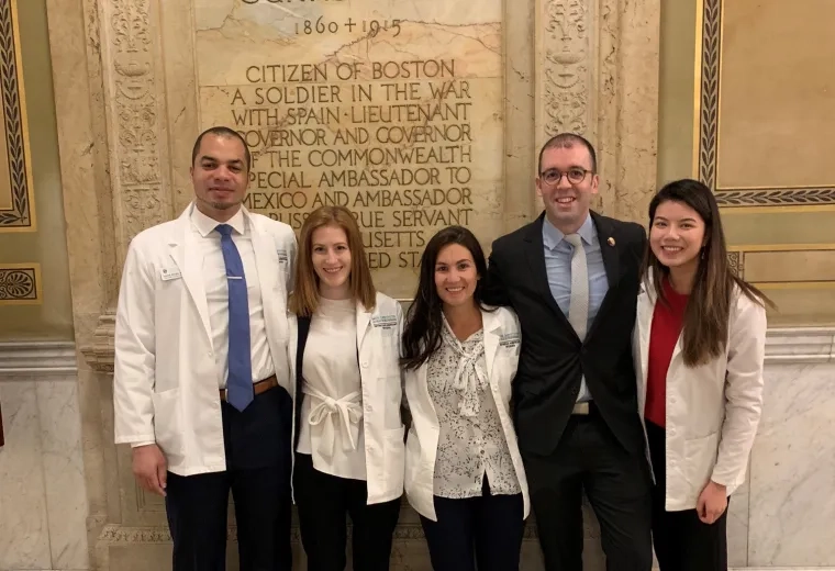 two men stand with three woman at state house