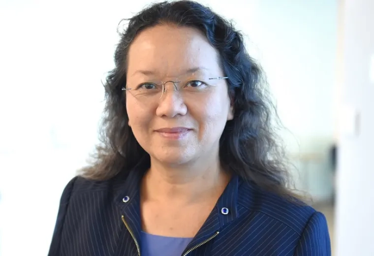 Professional portrait of an MGH IHP Doctor of Audiology faculty member in a modern indoor setting.
