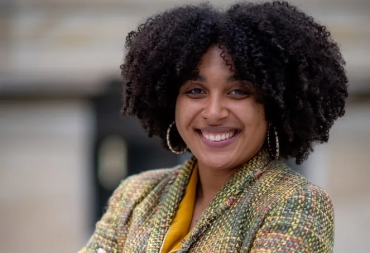 natalie wears her natural curls and gold hoop earrings