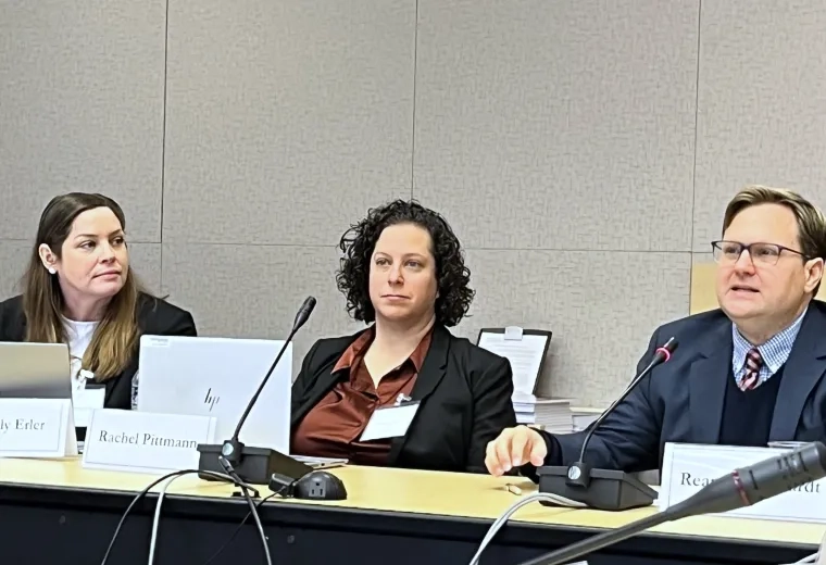Three people testifying while sitting at a table