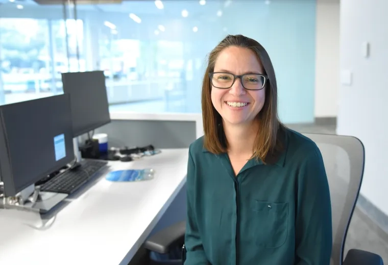 Woman sits at desk and smiles