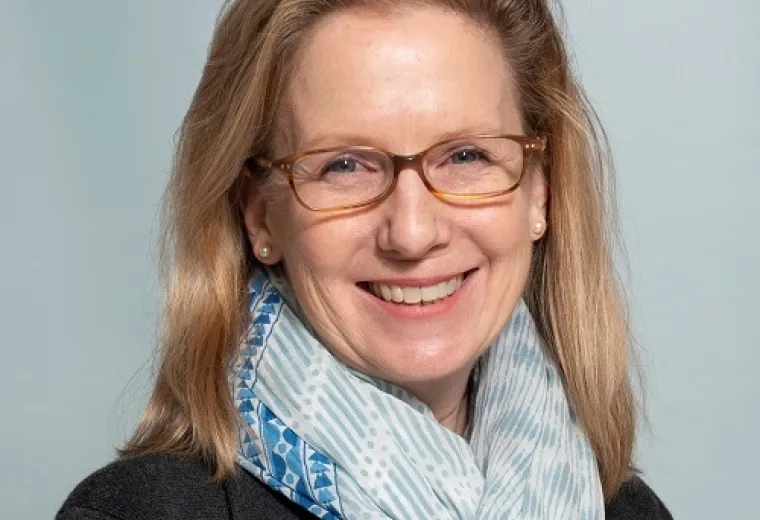 lynne wears a aqua patterned scarf and tortoiseshell glasses