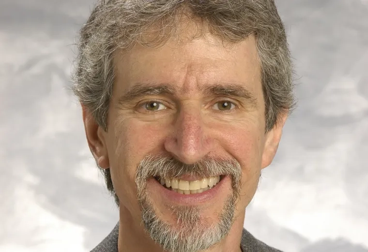 david has grey hair and goatee and wears a black shirt with a suit jacket