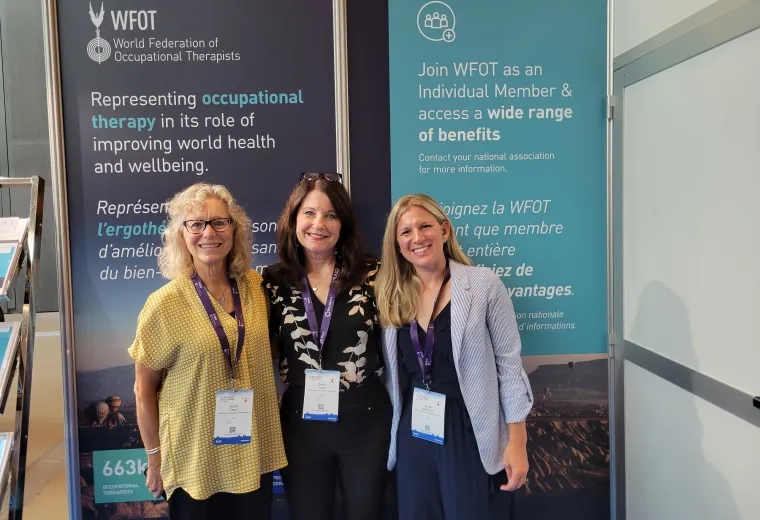 three women stand in front of a banner