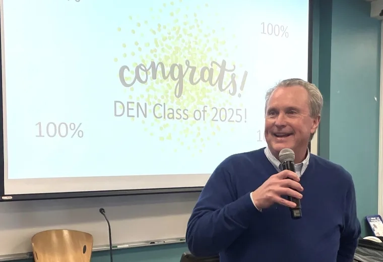 Man smiling, holding a mic