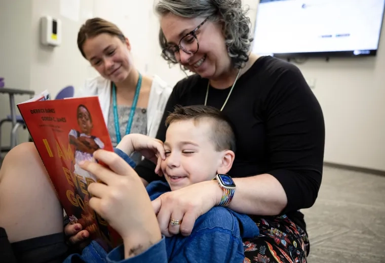 woman sits and reads with child