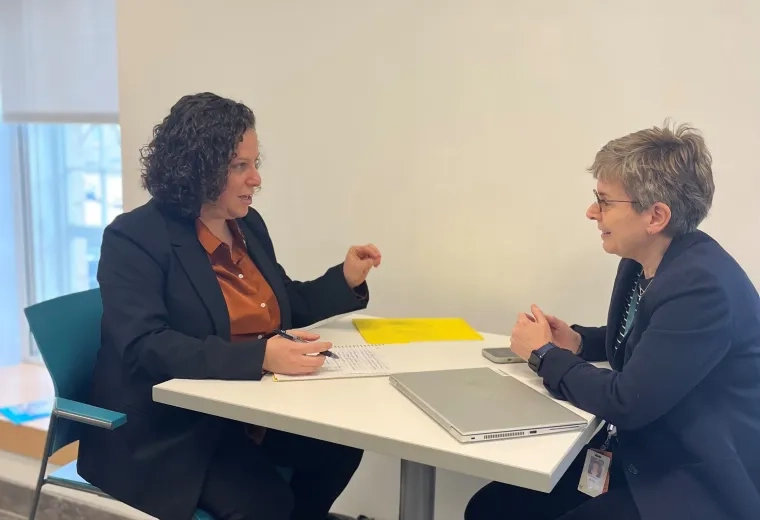 two women sit and discuss