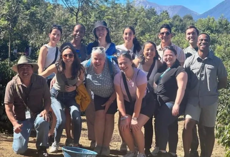 woman stands with group of students in guatemala