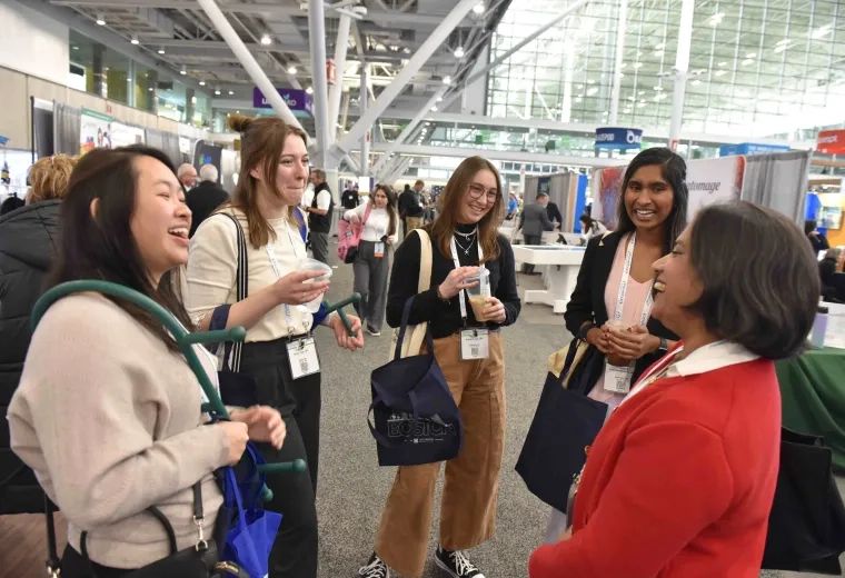 Five people standing and laughing