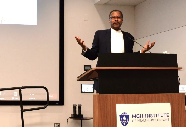 Man gesturing at podium during a talk