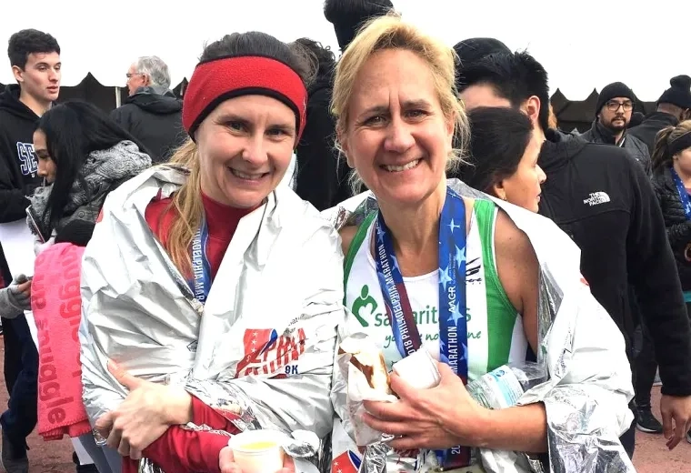 Two women smiling after running marathon