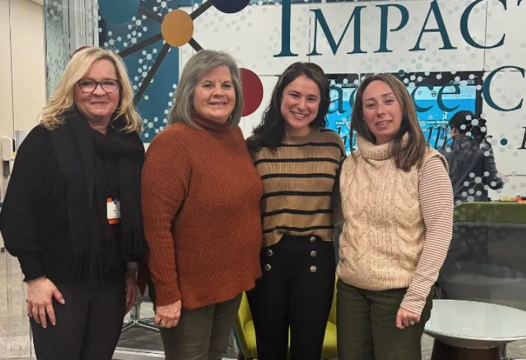 four women smile and pose