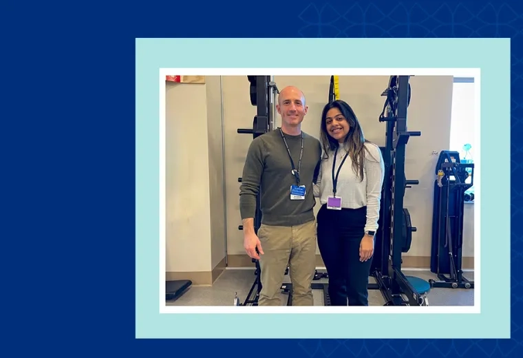 two people pose together in front of a room of exercise equipment