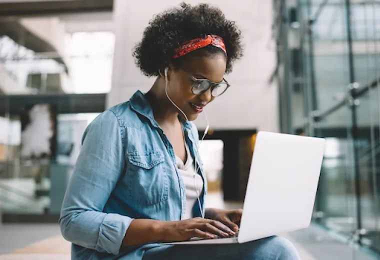 woman on laptop with earbuds