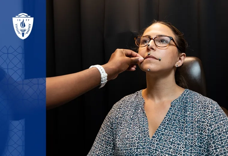 woman places small round sensors on another woman's face