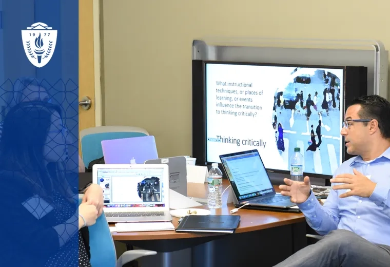 man gestures in a way that indicates teaching at a table with other adults