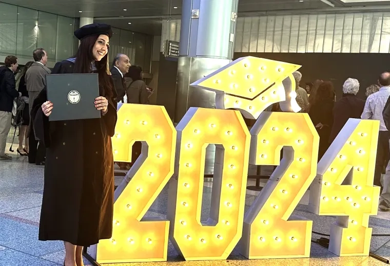 student poses with 2024 sign