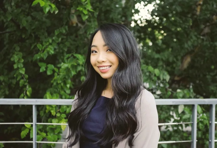 Woman smiles standing outside