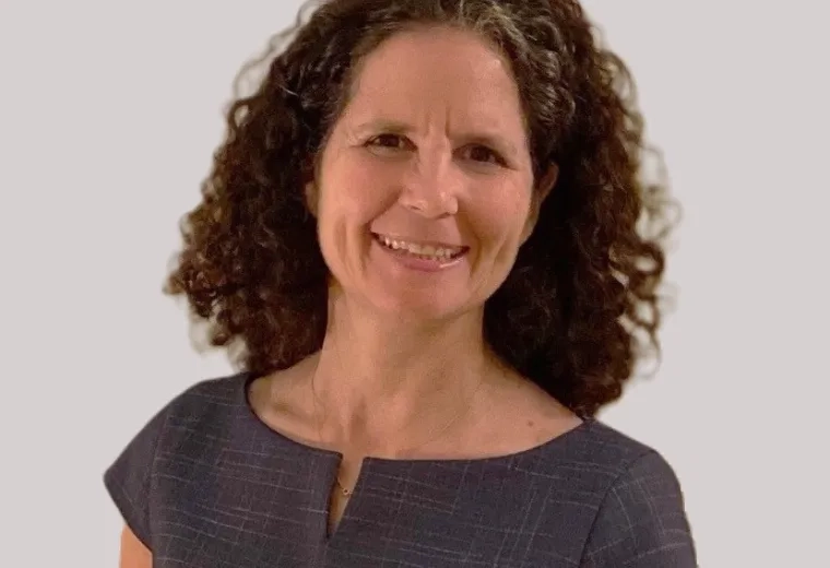 regina wears a cap sleeve navy top and has curly brown hair