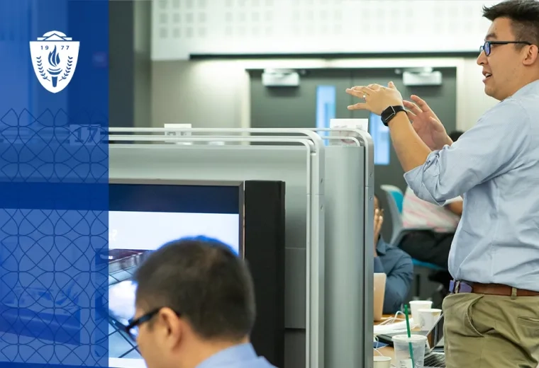 man gestures at front of classroom