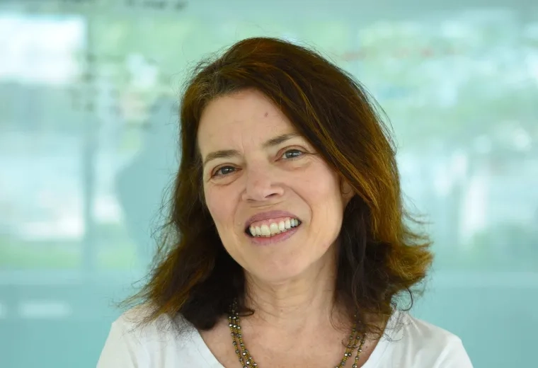 joyce stands in front of an aqua wall