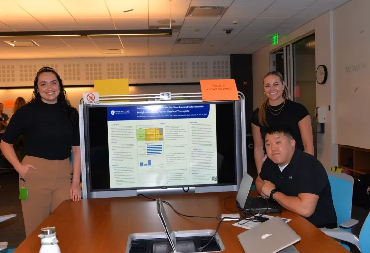 Three people in front of a screen presenting a project