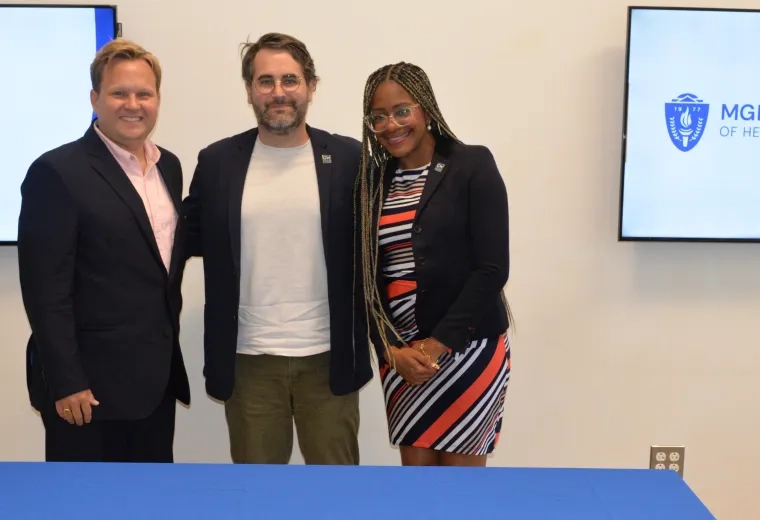3 people standing in front of a table. 
