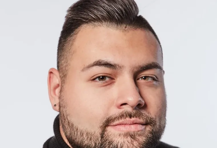 john wears a black turtleneck and has a close cropped beard