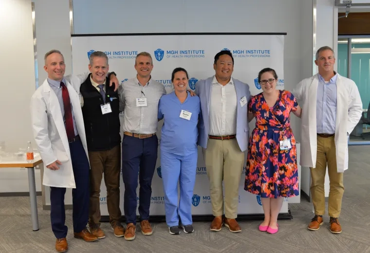 seven people stand in front of a backdrop. 