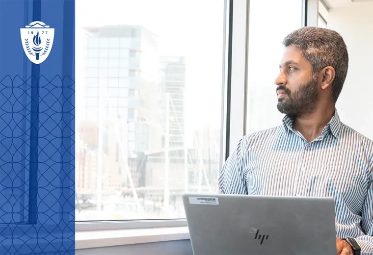 man at laptop looks out window