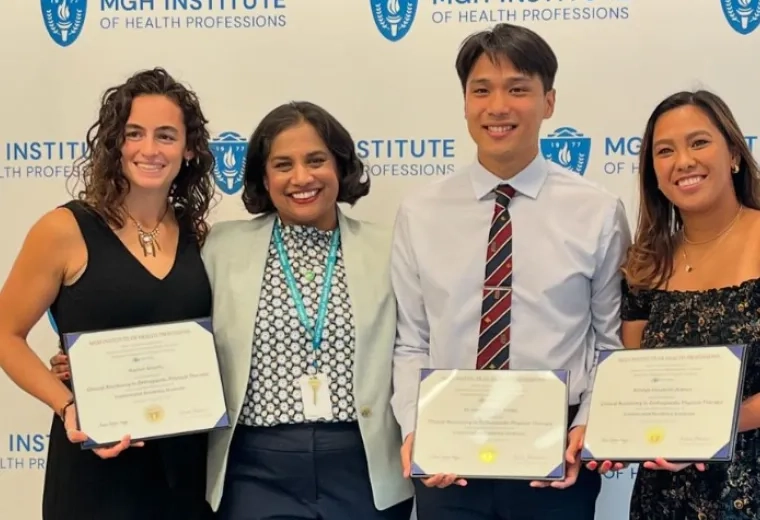 Four people pose in front of a backdrop holding certificates