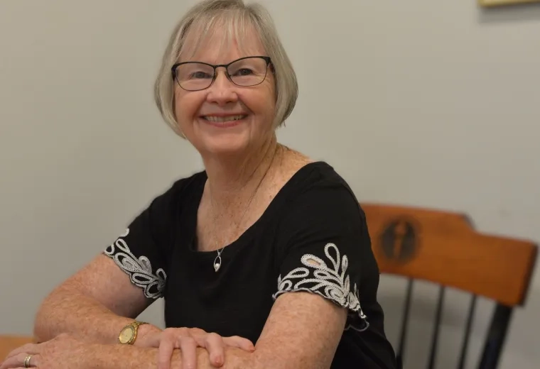 pat wears glasses and a black and white top