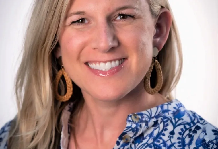 sarah has blonde hair and a blue patterned top