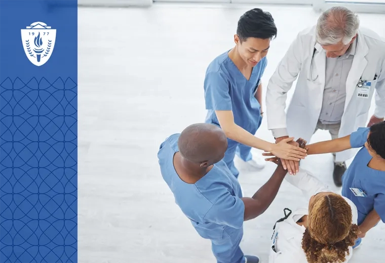 members of a healthcare team stand in a circle with their hands in representing teamwork