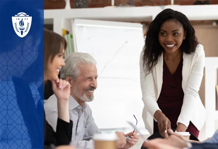 woman in white coat leading a meeting at a conference table