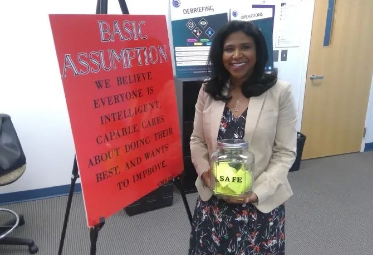 Woman holding a cannister in front of a poster board