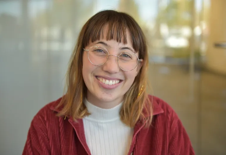 annika wears a maroon jacket and gold glasses