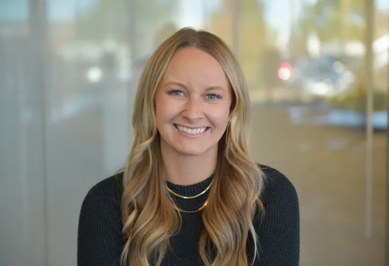 becca has a black sweater and layered gold necklaces