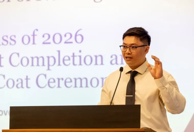 A man stands behind a podium speaking