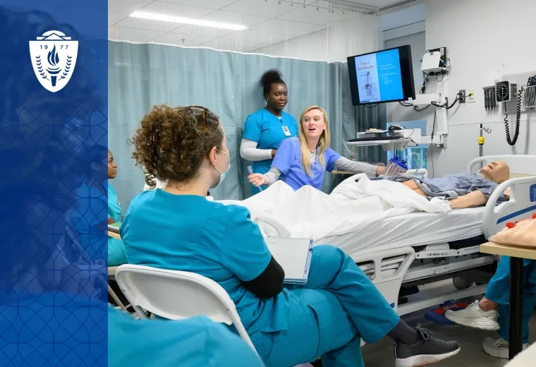 Simulation in healthcare education takes place with a manikin in a bed and nursing students in scrubs gathered around