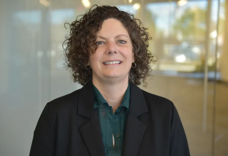 kate has curley dark brown hair and a black blazer